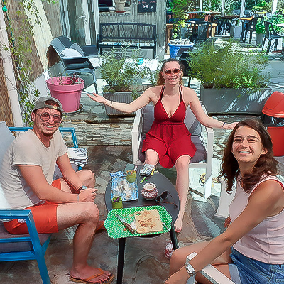3 personnes autour d'une table partageant un plateau de charcuterie